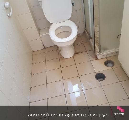 שירותים עם רצפה רטובה וכתמים ליד המקלחת